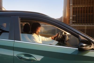 Woman in the drivers seat of the all-new Hyundai BAYON compact crossover SUV with panorama roof.