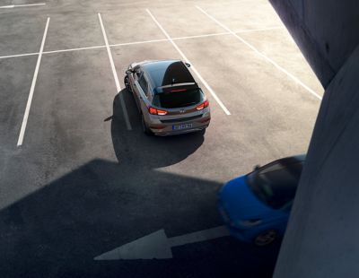 Rear view of the new Hyundai i30 backing out of an empty parking lot.
