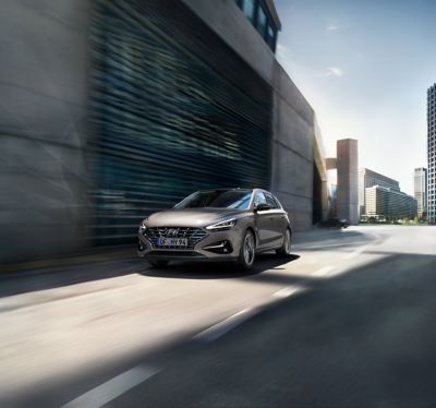 The new Hyundai i30 drivig in a concrete street.