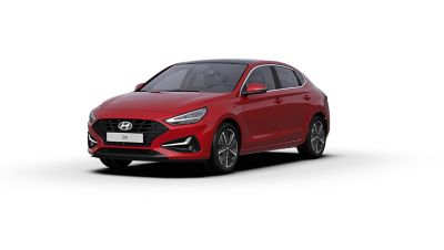 Front side view of the new Hyundai i30 Fastback in the colour Sunset Red.
