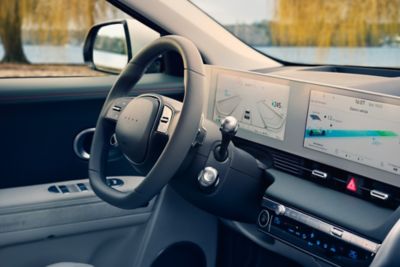 Interiér elektrického CUV strednej veľkosti Hyundai IONIQ 5 s volantom a digitálnym združeným prístrojom.