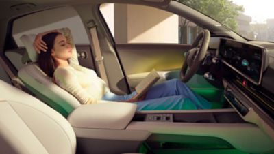 Žena odpočívajúca na sklopenom prednom sedadle elektrického sedanu Hyundai IONIQ 6. 