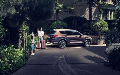 The new Hyundai SANTA FE Plug-in Hybrid 7 seat SUV from the front, parked in front of a house.