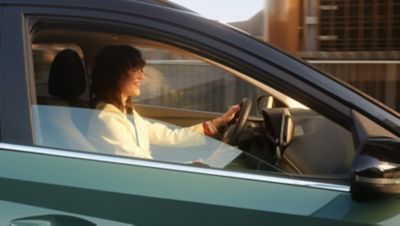 Žena sediaca za volantom svojho automobile Hyundai, hovoriaca.
