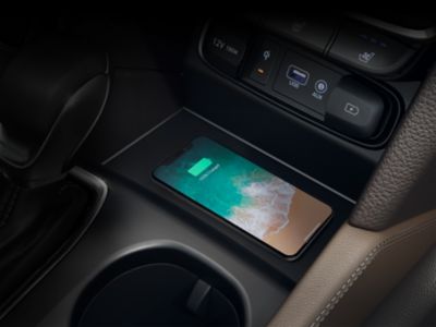 Mobilný telefón kompatibilný s Qi v priehradke na bezdrôtové nabíjanie v stredovej konzole Hyundai.