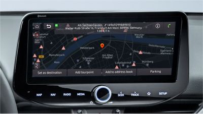 Detailný pohľad na obrazovku s navigáciou v modeli Hyundai s polohou garáží vrátane cien parkovného.