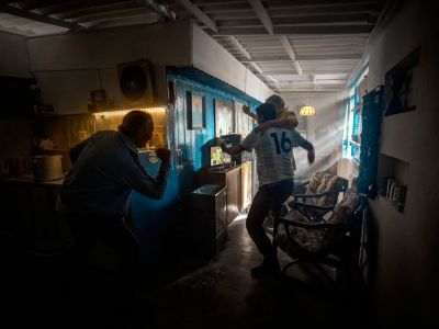 Futbaloví fanúšikovia oslavujúci doma pri televízii, oblečení do dresu Argentíny.