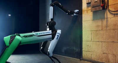 Spot, štvornohý robot Boston Dynamics vo farbách Hyundai Team Century otvárajúci dvere.