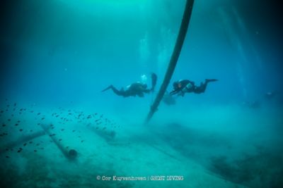 2 potápači z Ghost Divers zbierajú pod vodou odpad v mori.