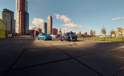Hyundai's family of electrified cars parked in front of a cityscape.